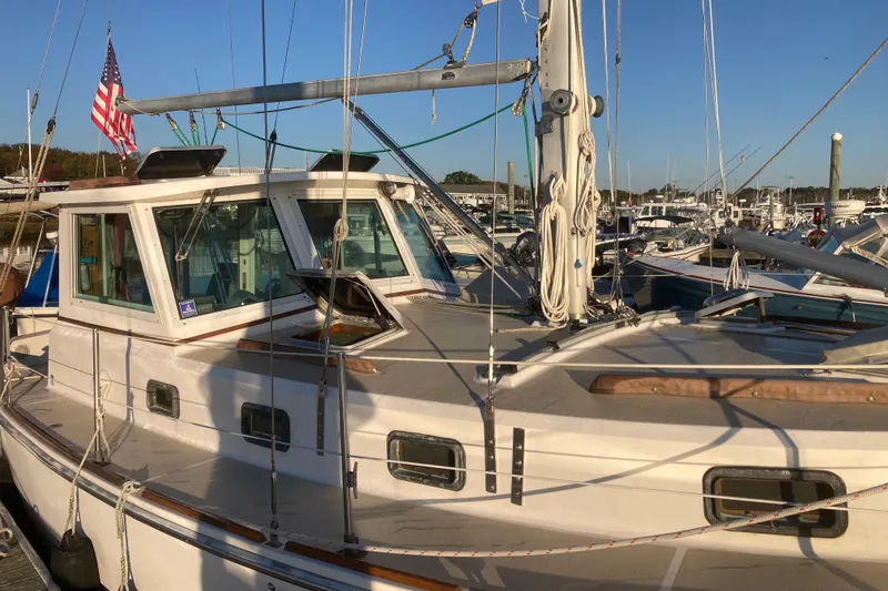Slide: The Image of 1989 Cape Dory 300 Motorsailer docked, featuring classic design and American flag. - 3