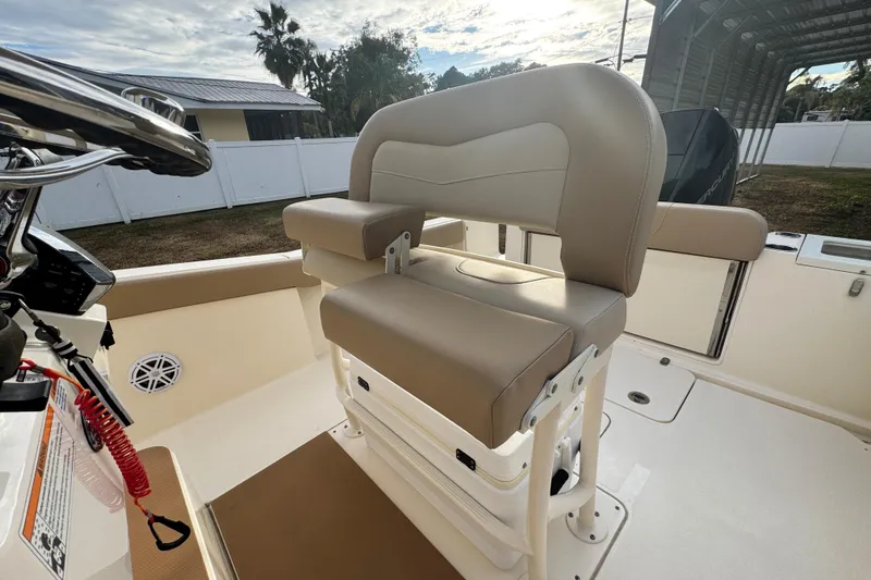 Slide: The Image of 2023 Scout 240 XSF boat interior with beige seating and steering console. - 15