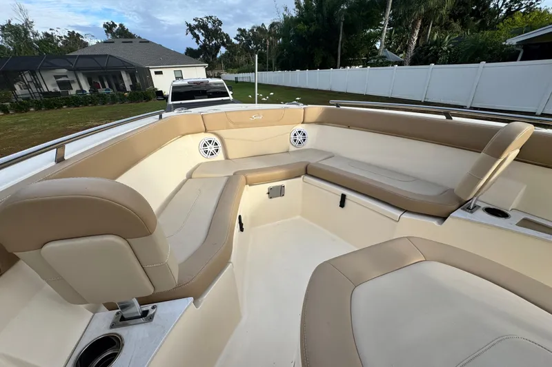 Slide: The Image of 2023 Scout 240 XSF boat interior with beige seating and cup holders. - 19