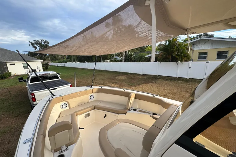 Slide: The Image of 2023 Scout 240 XSF boat with canopy, parked in a residential yard. - 22