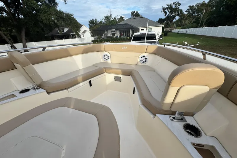 Slide: The Image of 2023 Scout 240 XSF boat interior with beige seating and cup holders. - 27