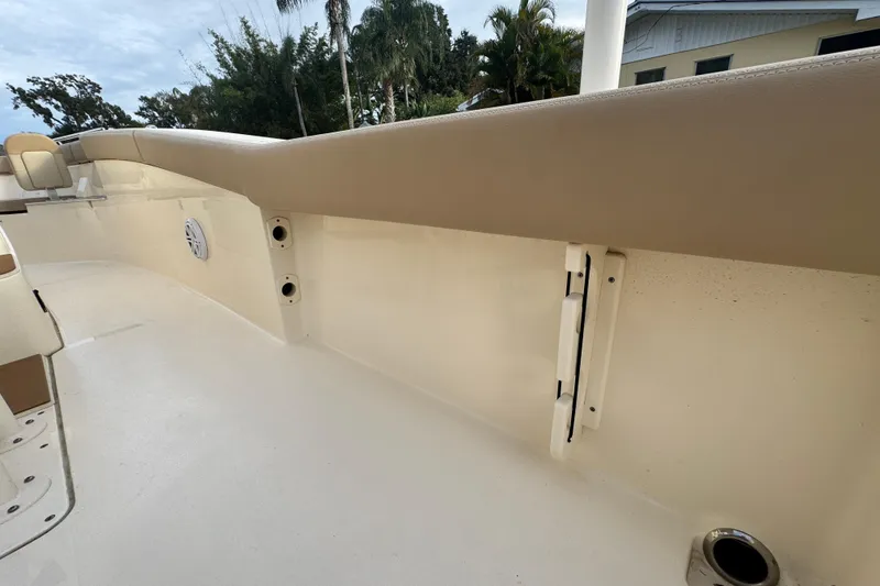Slide: The Image of 2023 Scout 240 XSF boat interior with beige seating and speaker. - 33
