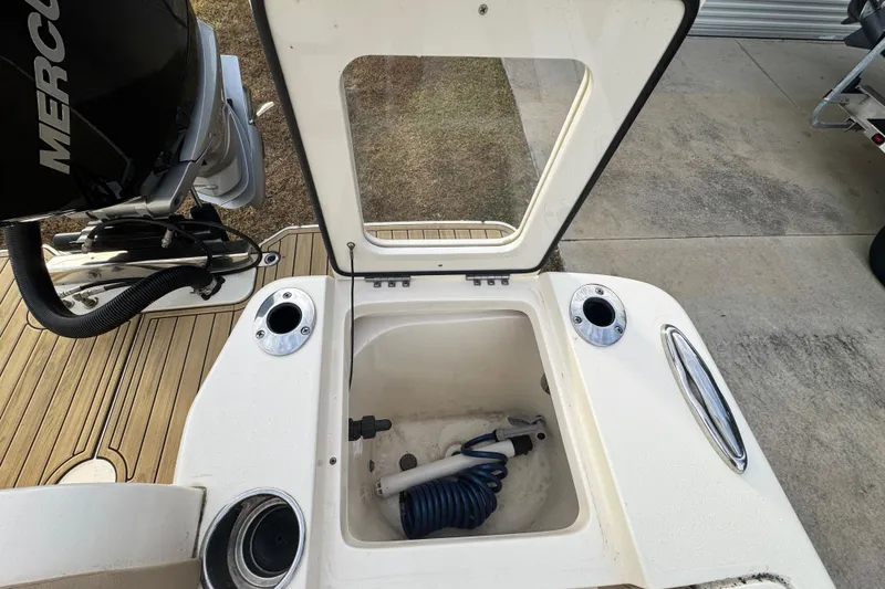 Slide: The Image of 2023 Scout 240 XSF boat with open storage compartment and Mercury engine. - 34