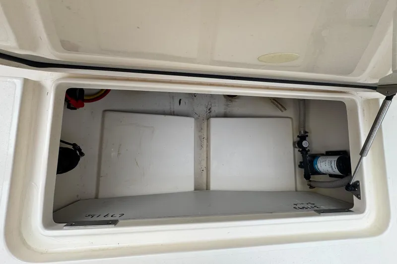 Slide: The Image of Storage compartment of 2023 Scout 240 XSF boat, featuring internal components and wiring. - 35
