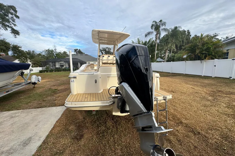 Slide: The Image of 2023 Scout 240 XSF boat with outboard motor on grassy yard. - 8