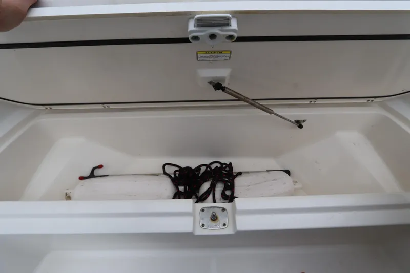 Slide: The Image of Open storage compartment in 2013 Boston Whaler 210 Montauk boat with rope and fender. - 19