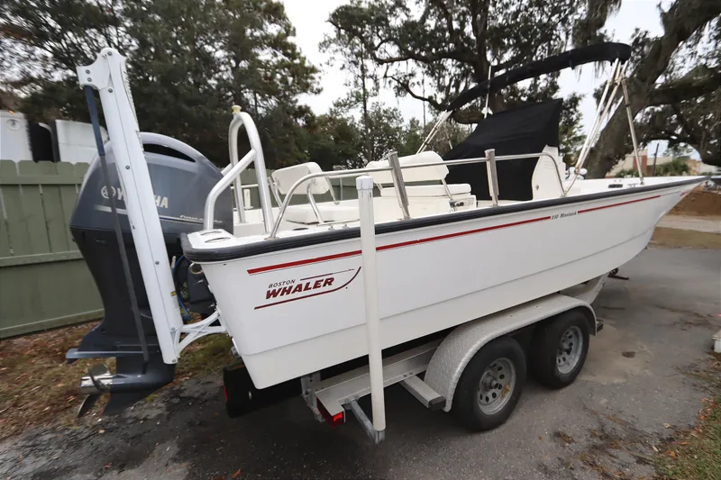 Slide: The Image of 2013 Boston Whaler 210 Montauk boat on trailer, parked outdoors. - 2