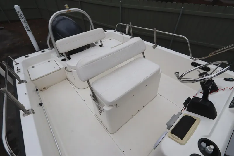 Slide: The Image of 2013 Boston Whaler 210 Montauk boat interior with white seating and steering wheel. - 6