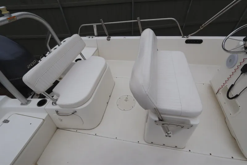 Slide: The Image of 2013 Boston Whaler 210 Montauk boat interior with white seating and steering console. - 7