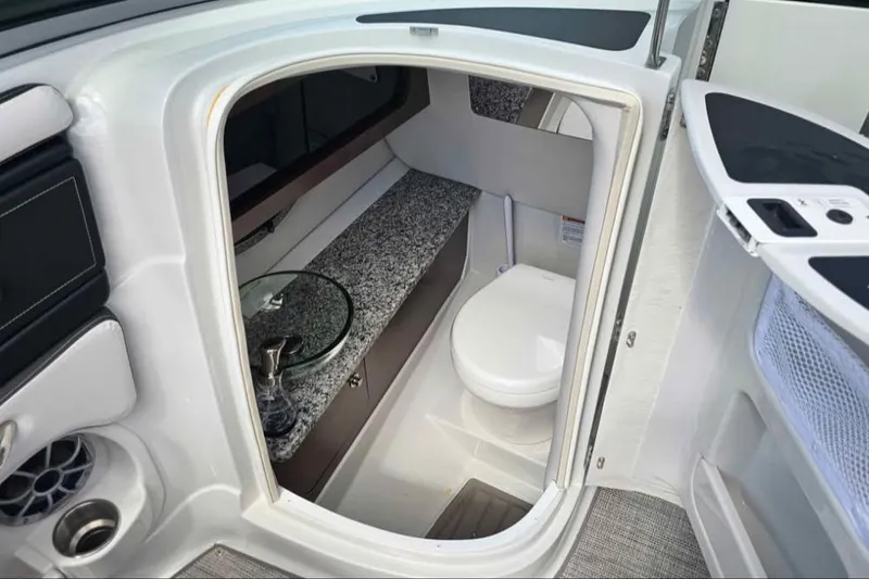 Slide: The Image of 2024 Crownline Eclipse E290 XS boat interior with compact bathroom and modern amenities. - 10