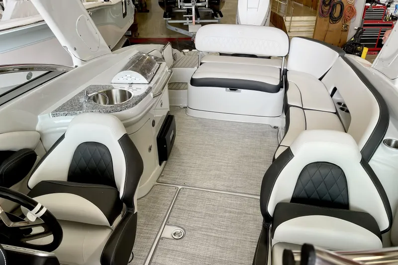 Slide: The Image of 2024 Crownline Eclipse E290 XS boat interior with luxurious seating and kitchenette. - 13