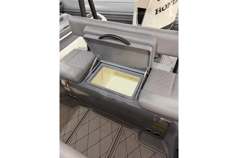 Slide: The Image of 2026 Brig Navigator 24 boat interior with open storage compartment and Honda engine. - 13