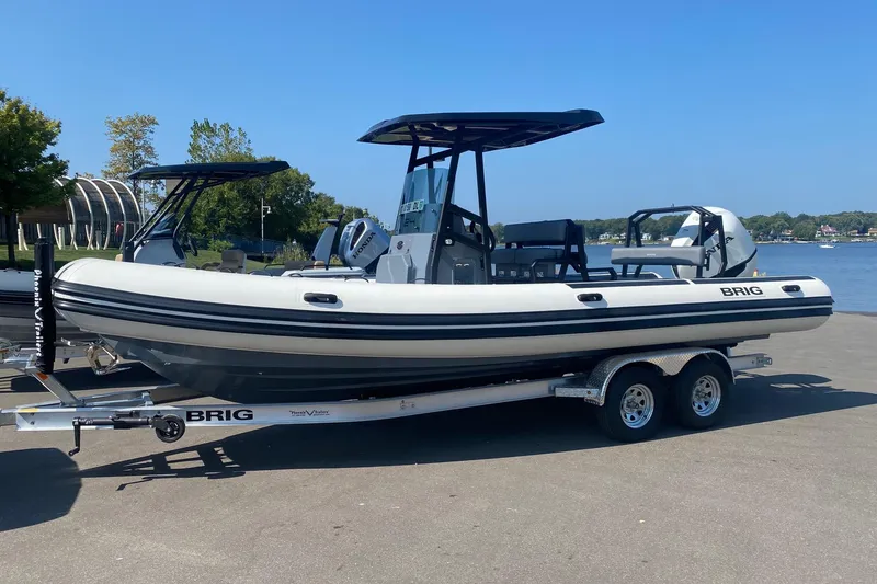 Slide: The Image of 2026 Brig Navigator 24 boat on trailer by waterfront, clear sky background. - 4