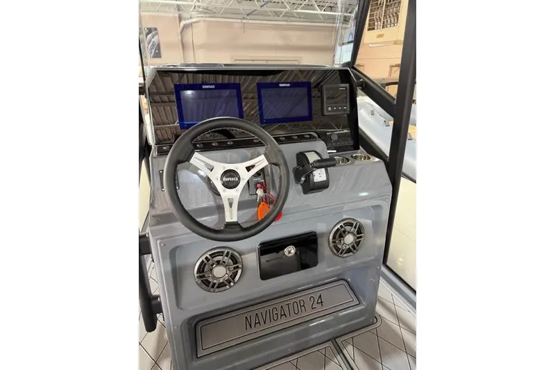 Slide: The Image of 2026 Brig Navigator 24 boat dashboard with steering wheel and digital displays. - 6