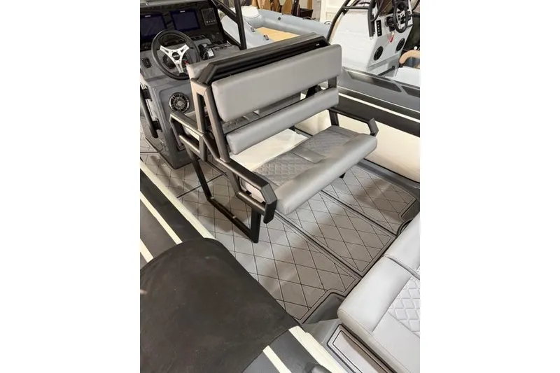 Slide: The Image of 2026 Brig Navigator 24 boat interior with gray seating and modern dashboard. - 9