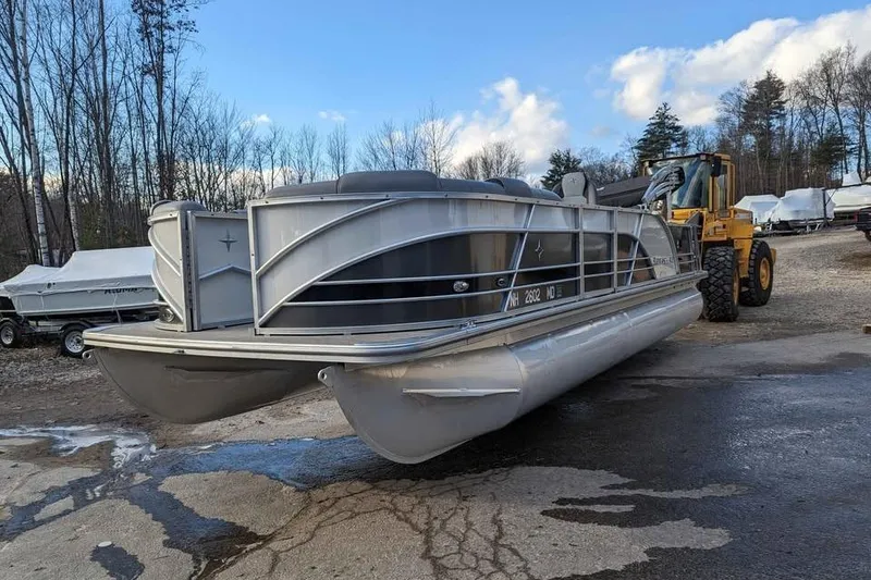 Slide: The Image of 2021 Berkshire 23ULX pontoon boat on a trailer in a wooded area. - 2