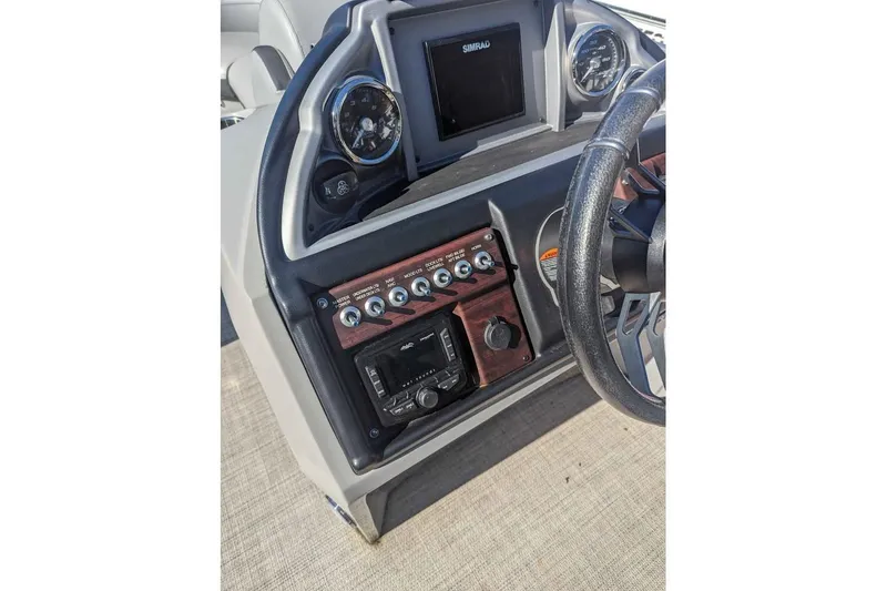 Slide: The Image of 2021 Berkshire 23ULX boat dashboard with steering wheel and control panel. - 8