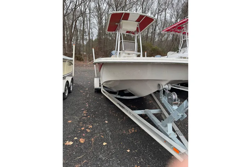 Slide: The Image of 2017 Carolina Skiff 218 DLV boat on trailer, parked in wooded area. - 1