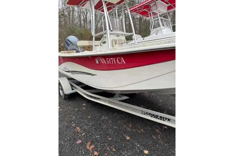 Slide: The Image of 2017 Carolina Skiff 218 DLV boat on trailer, red and white design, parked outdoors. - 5