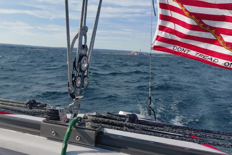 Slide: The Image of Sailing on a 1979 Newick Native boat with "Don't Tread On Me" flag in the wind. - 4