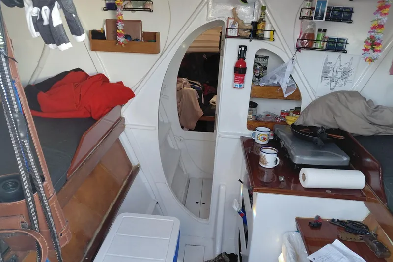 Slide: The Image of Interior of a 1979 Newick Native sailboat with cozy living space and kitchen area. - 9