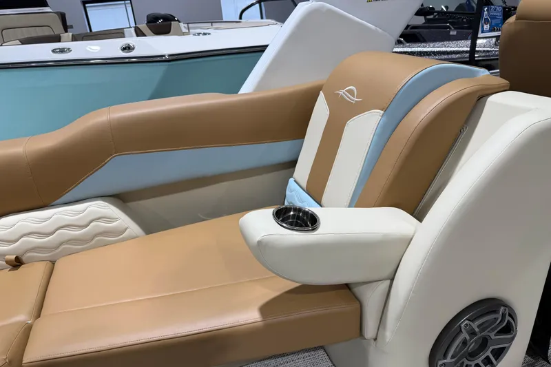 Slide: The Image of 2026 SunCatcher Diamond Elite 324 RC boat interior with tan and blue seating, cup holder, and speaker. - 11