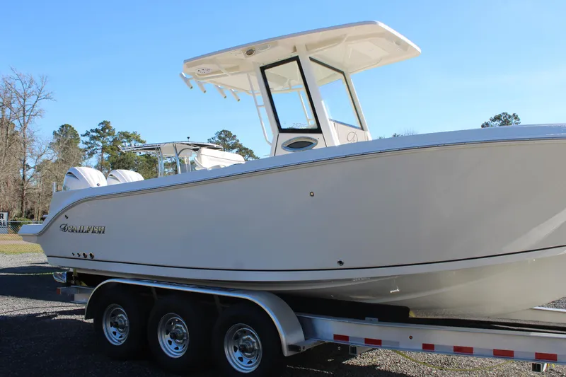 Slide: The Image of 2026 Sailfish 252 CC boat on trailer, side view under clear blue sky. - 20