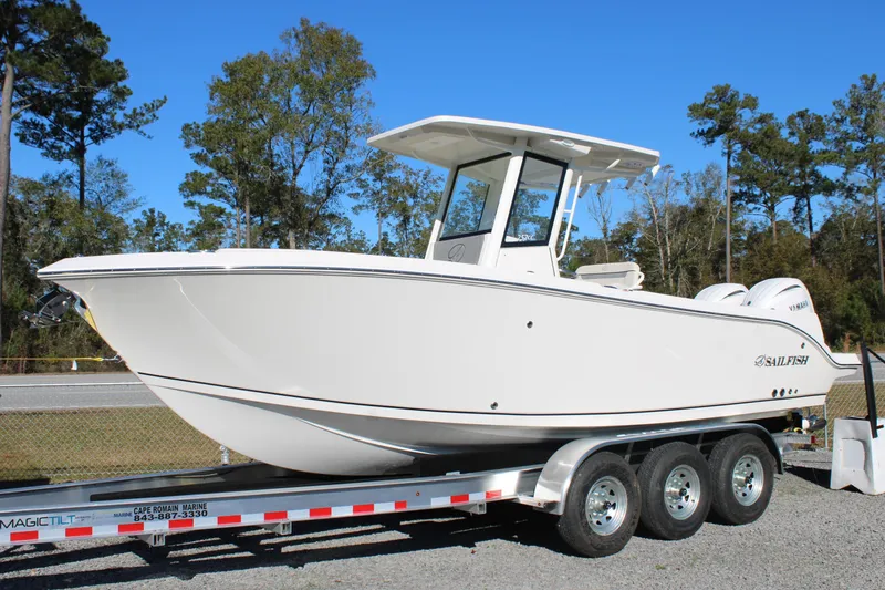 Slide: The Image of 2026 Sailfish 252 CC boat on trailer, parked outdoors with trees in background. - 3