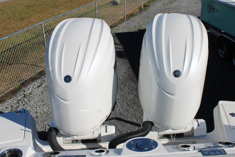 Slide: The Image of Twin outboard engines on a 2026 Sailfish 252 CC boat, parked on gravel. - 35