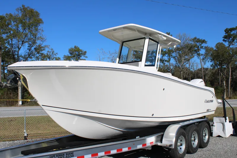 Slide: The Image of 2026 Sailfish 252 CC boat on trailer, parked outdoors under clear blue sky. - 44