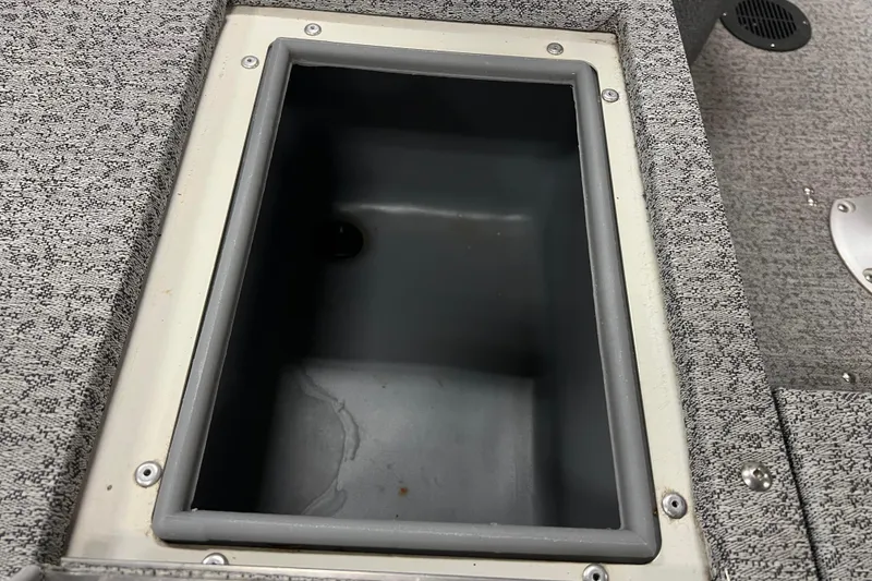 Slide: The Image of Storage compartment in 2022 Tracker Pro Guide V-16 WT boat, featuring gray interior and textured surface. - 17