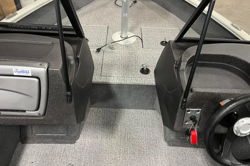Slide: The Image of 2022 Tracker Pro Guide V-16 WT boat interior with steering wheel and carpeted floor. - 22