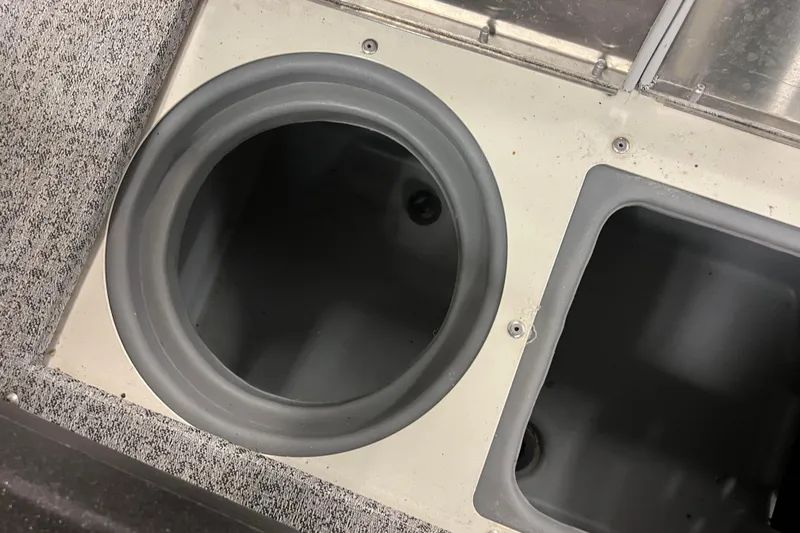 Slide: The Image of 2022 Tracker Pro Guide V-16 WT boat storage compartments, circular and rectangular, with carpeted surface. - 29