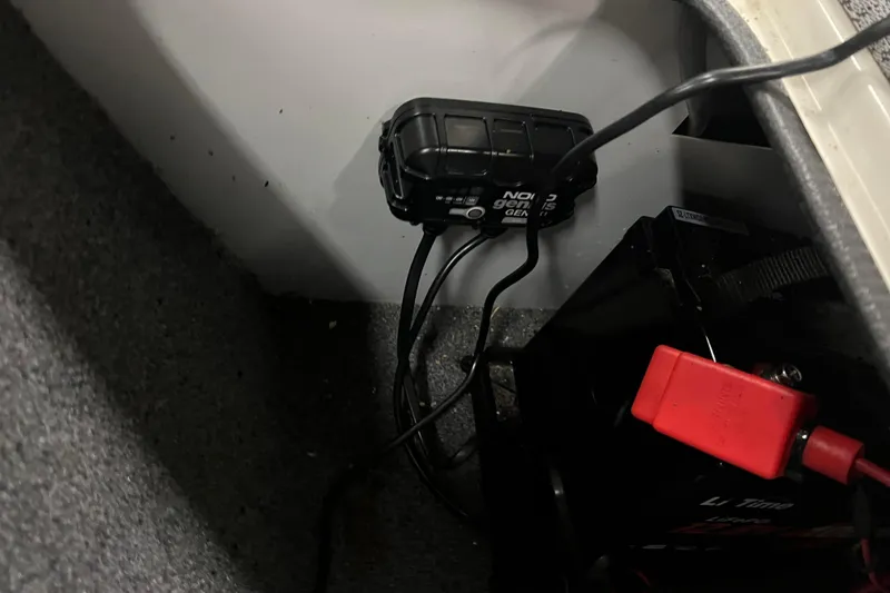 Slide: The Image of 2022 Tracker Pro Guide V-16 WT battery compartment with charger and wiring. - 32