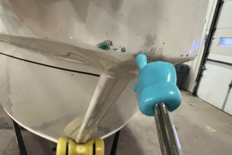 Slide: The Image of 2022 Tracker Pro Guide V-16 WT boat hull with visible damage and repair tool. - 60