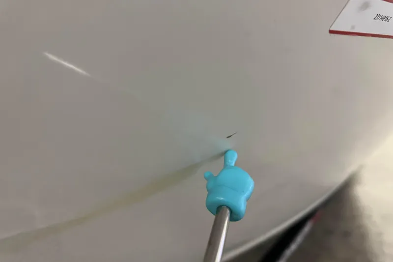 Slide: The Image of Close-up of a 2022 Tracker Pro Guide V-16 WT boat hull with a small scratch. - 61