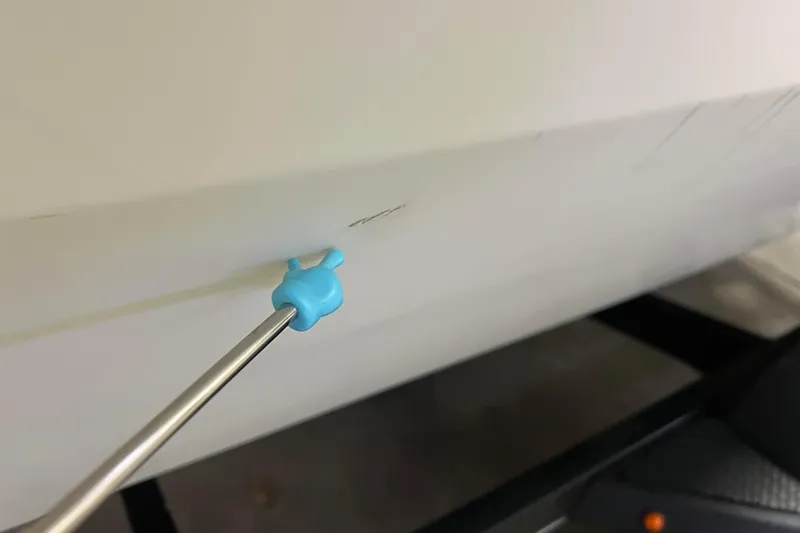 Slide: The Image of Close-up of a 2022 Tracker Pro Guide V-16 WT boat with a small scratch. - 62