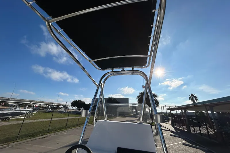 Slide: The Image of 2026 Shallow Stalker CAT 211 PRO boat with canopy under clear blue sky. - 13