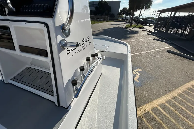 Slide: The Image of Shallow Stalker CAT 211 PRO 2026 boat console with rod holders in a parking lot. - 14