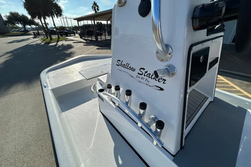 Slide: The Image of 2026 Shallow Stalker CAT 211 PRO boat console with rod holders in sunny outdoor setting. - 15