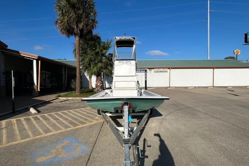 Slide: The Image of 2026 Shallow Stalker CAT 211 PRO boat on trailer in parking lot. - 2