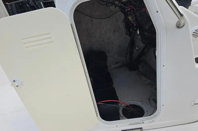Slide: The Image of Open compartment of 2011 Tidewater 2400 Bay Max boat showing wiring and storage space. - 13