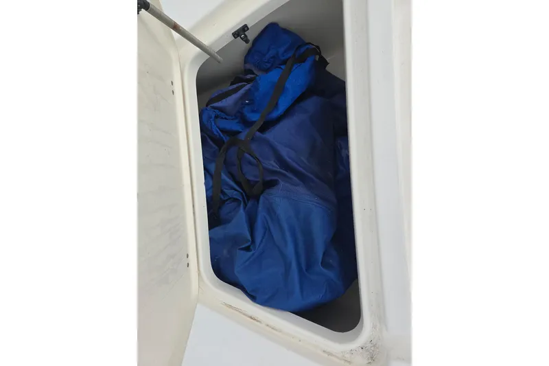 Slide: The Image of Storage compartment of 2011 Tidewater 2400 Bay Max boat with blue tarp inside. - 16