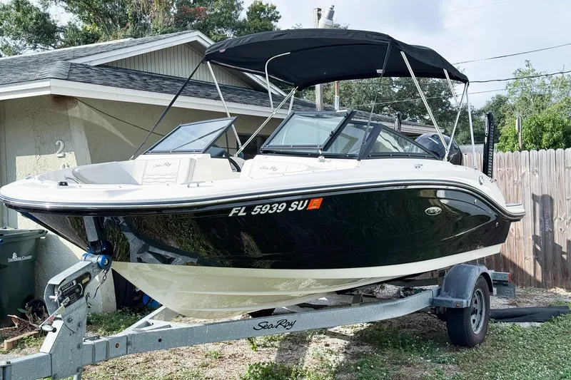 Slide: The Image of 2021 Sea Ray SPX 190 Outboard boat on trailer, parked beside a house. - 3