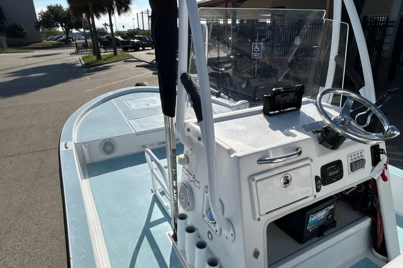 Slide: The Image of 2016 Shallow Sport 21 Sport boat, featuring a sleek console and steering wheel in a sunny setting. - 11