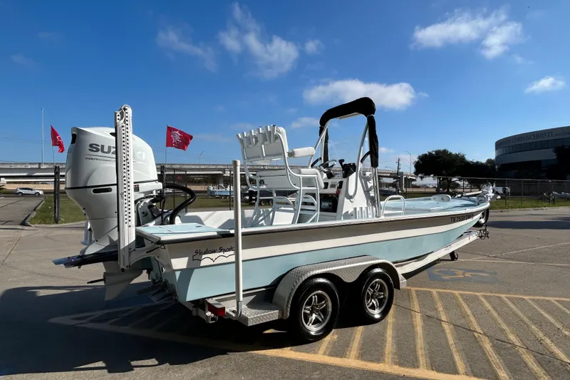 Slide: The Image of 2016 Shallow Sport 21 Sport boat on trailer, featuring Suzuki outboard motor. - 6