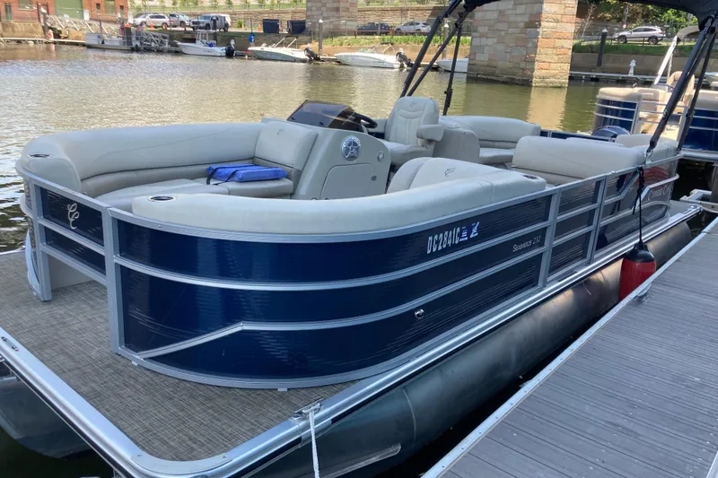 Slide: The Image of 2023 Cypress Cay Seabreeze 232 pontoon boat docked, featuring sleek blue exterior and spacious seating. - 2