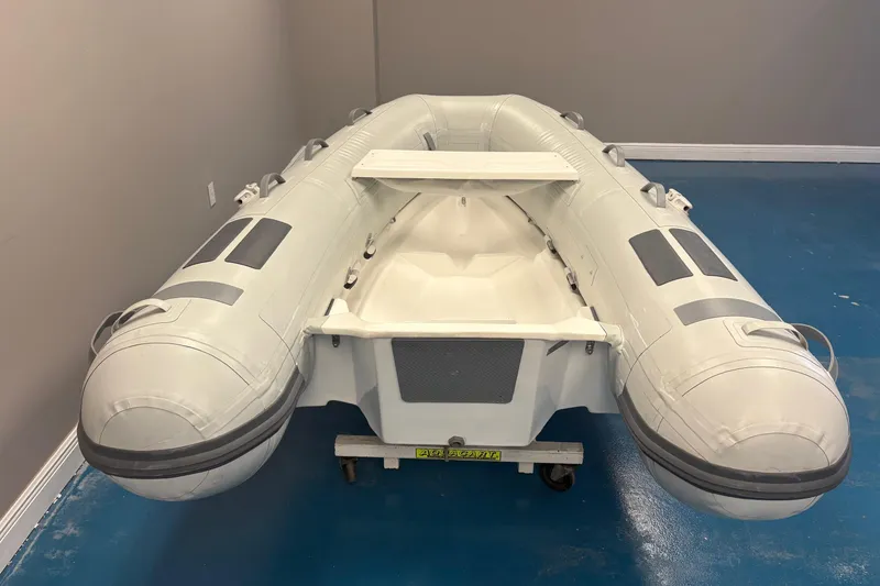 Slide: The Image of Inflatable Caribe L-8 boat, 2025 model, displayed indoors with motor and plants. - 5