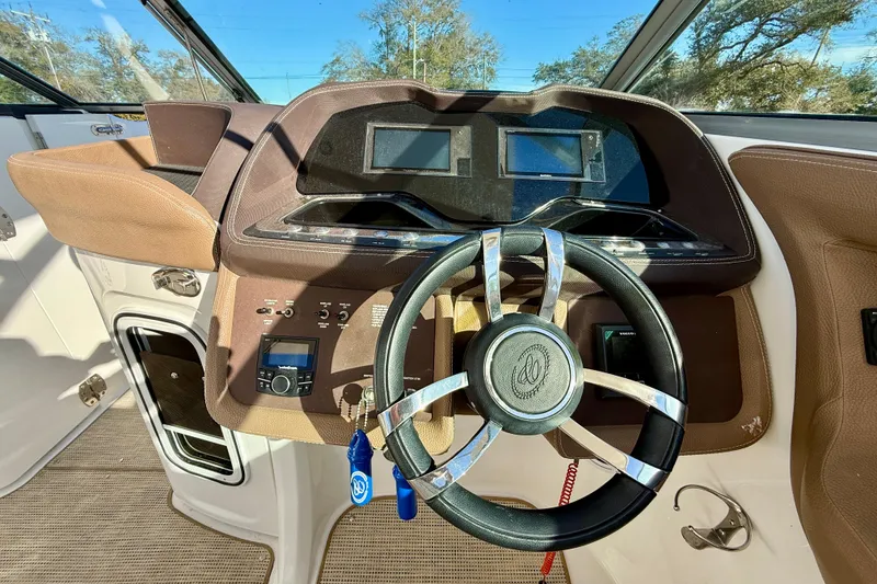 Slide: The Image of Steering wheel and dashboard of 2018 Cobalt R35 boat, featuring modern controls and displays. - 13
