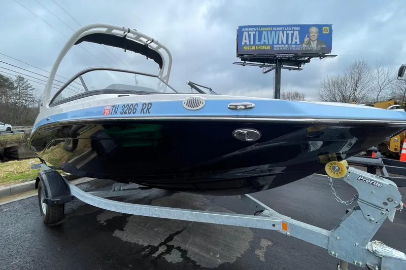 The Image of 2025 Yamaha Boats 195S on trailer, parked outdoors under cloudy sky. - 0